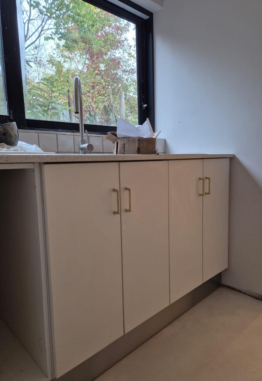 **Scullery** \nThis scullery, part of a home renovation, features repurposed kitchen cupboards paired with new handles and an engineered quartz countertop to echo the main kitchen’s modern farmhouse look.