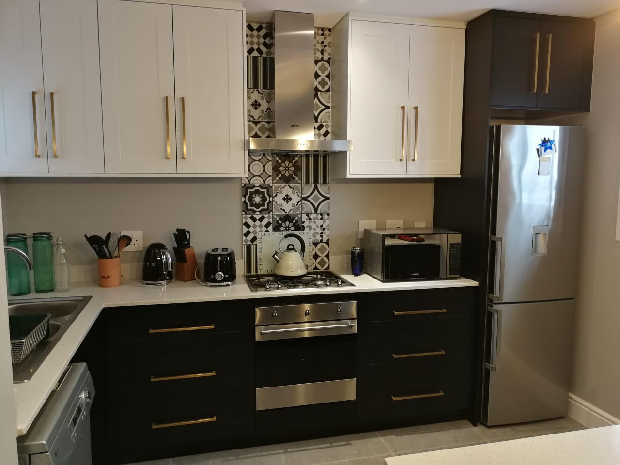 Kitchen A patterned splashback as a focus poin draws the eye.Floor to ceiling cupboards maximise storage space.